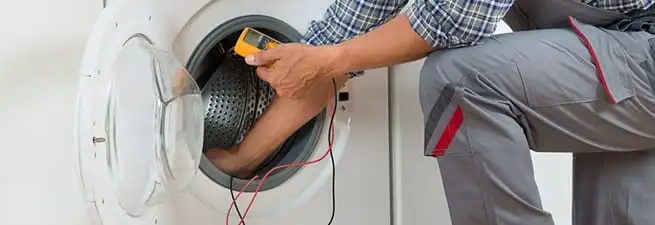 Dryer repair technician inspecting and repairing a clothes dryer in Reno, NV