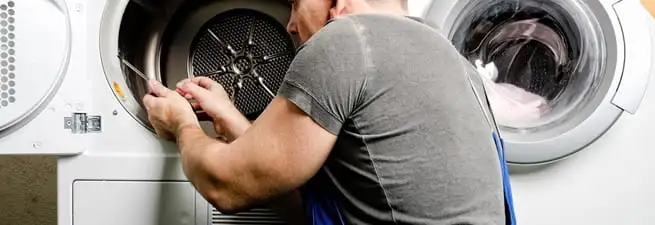 Dryer repair technician fixing a clothes dryer drum in Reno, NV