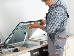 Appliance repair technician installing a built-in cooktop in Reno, NV