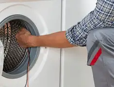Dryer repair technician diagnosing and servicing a clothes dryer in Reno, NV
