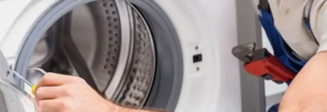 Appliance technician repairing a clothes dryer drum and internal parts in Reno, NV