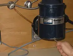 Garbage disposal repair technician tightening the mounting ring under a sink in Reno, NV