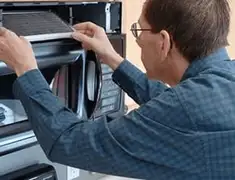 Appliance repair technician replacing a microwave vent filter in Reno, NV