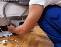 Appliance repair technician fixing refrigerator water line and connections in Reno, NV