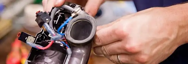 Vacuum repair technician reconnecting wiring and components in Reno, NV