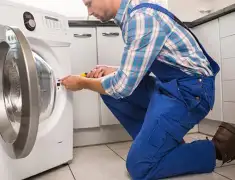 Washing machine repair technician servicing a front-load washer in Reno, NV