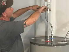 Water heater repair technician tightening supply line connections in Reno, NV