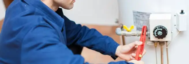 Water heater repair technician adjusting the temperature control and gas valve in Reno, NV